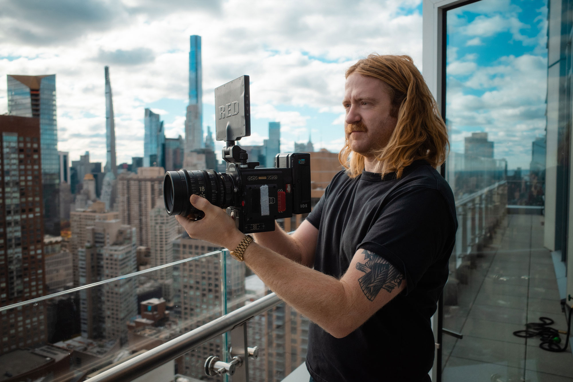 Matt Rogers holding a RED camera above the city skyline